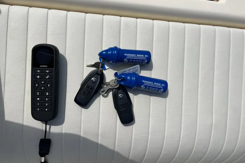 Slide: The Image of Remote and keys on a 2025 Jones Brothers 23 Cape Fisherman Lite Tackle boat seat. - 7