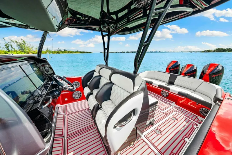 Slide: The Image of 2022 Nor-Tech 390 SS boat interior with luxurious seating and multiple engines on a sunny day. - 17
