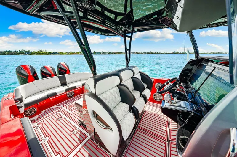 Slide: The Image of 2022 Nor-Tech 390 SS boat interior with luxurious seating and advanced controls on a sunny day. - 18