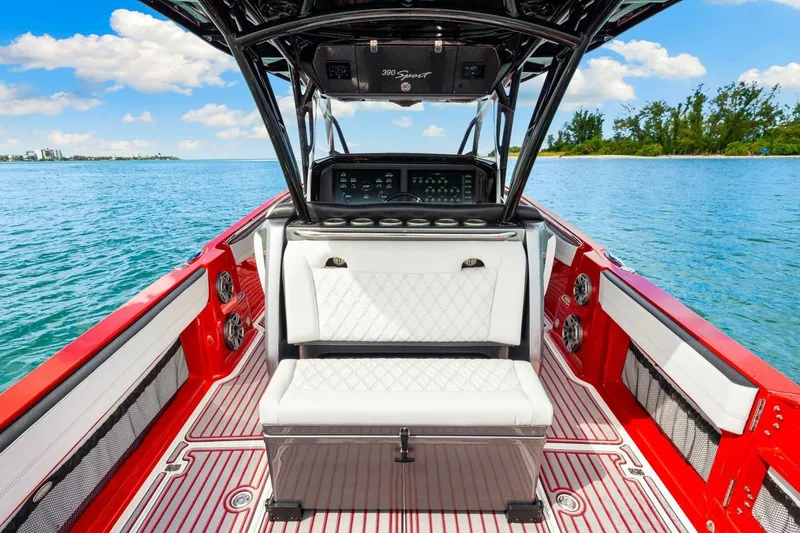 Slide: The Image of 2022 Nor-Tech 390 SS boat interior with red accents, white seating, and ocean view. - 19