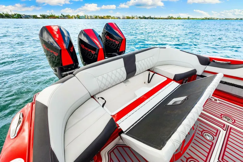 Slide: The Image of 2022 Nor-Tech 390 SS boat with triple outboard engines, luxurious seating, and vibrant red accents. - 21
