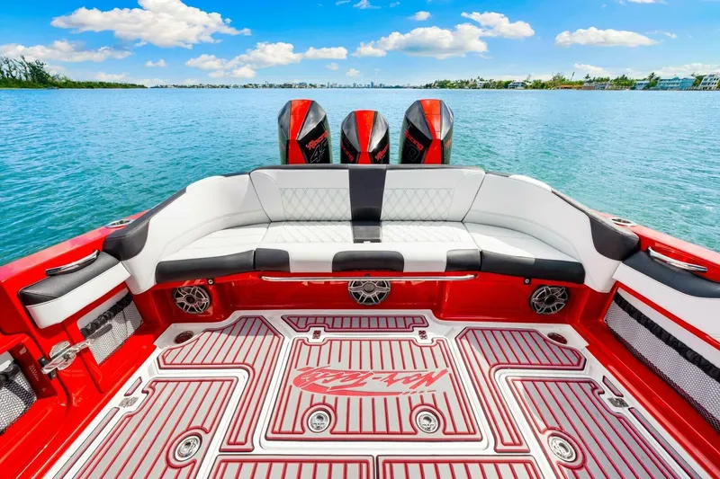 Slide: The Image of Luxurious 2022 Nor-Tech 390 SS boat interior with red and white seating, on a serene water backdrop. - 22