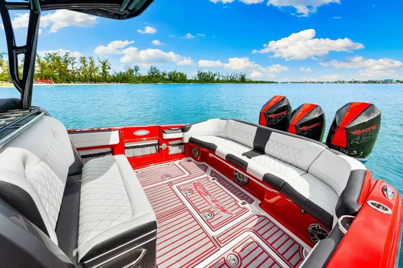 Slide: The Image of 2022 Nor-Tech 390 SS boat interior with luxurious seating and powerful engines on a serene lake. - 23
