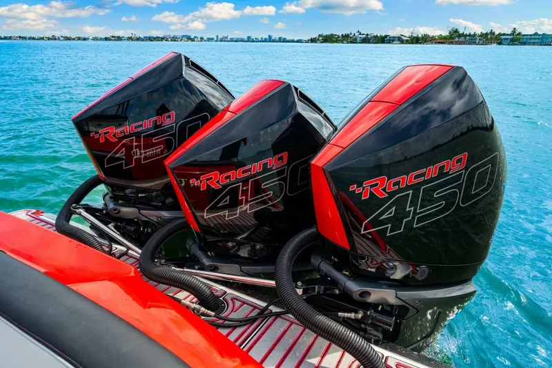 Slide: The Image of Triple Mercury Racing 450 engines on a 2022 Nor-Tech 390 SS boat in clear blue water. - 24