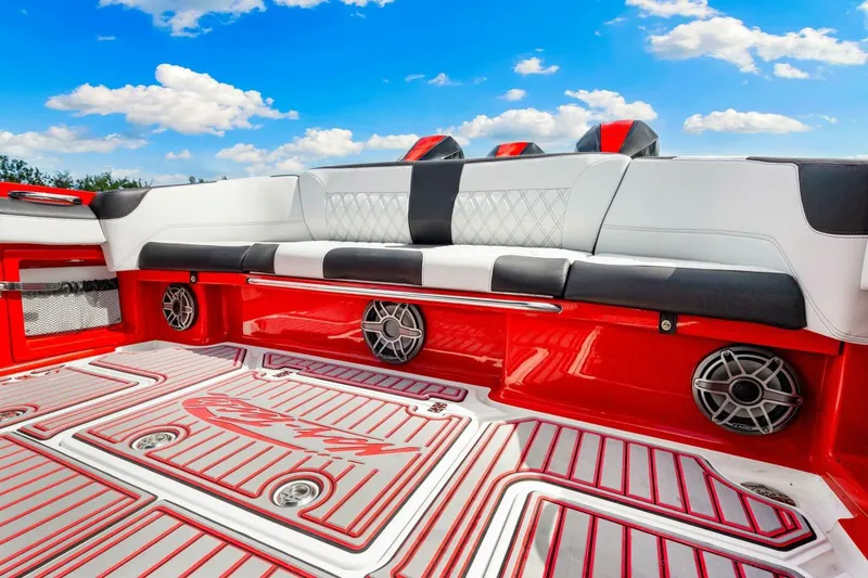 Slide: The Image of 2022 Nor-Tech 390 SS boat interior with red and white seating, speakers, and blue sky background. - 26