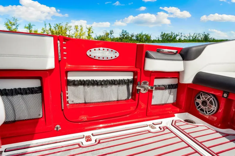 Slide: The Image of 2022 Nor-Tech 390 SS boat interior with red accents and seating, under a blue sky. - 27