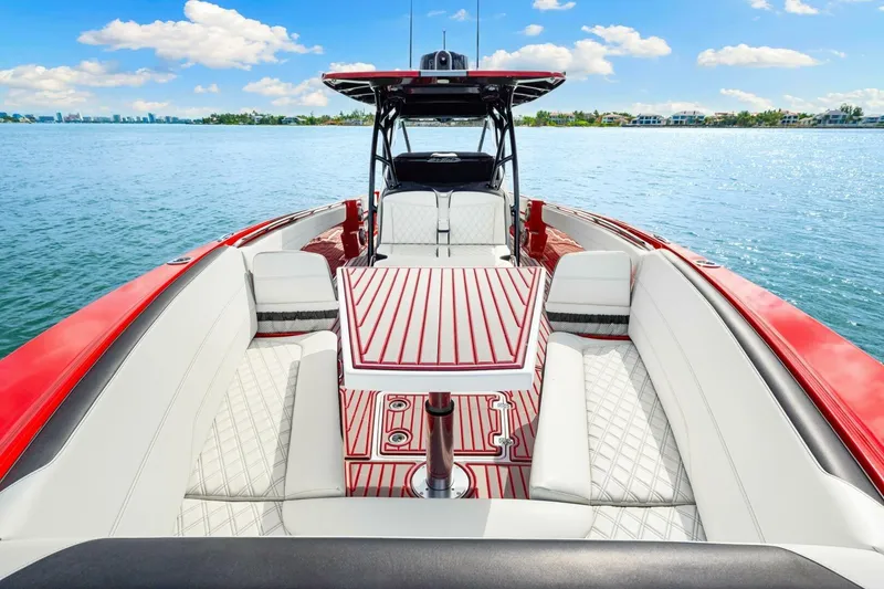 Slide: The Image of 2022 Nor-Tech 390 SS boat interior with red accents on a sunny day. - 3