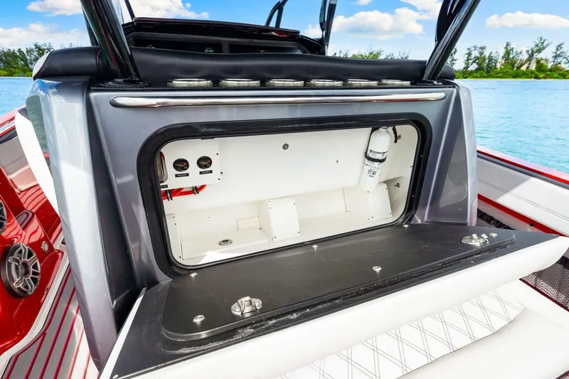 Slide: The Image of 2022 Nor-Tech 390 SS boat storage compartment with open hatch, featuring sleek design and ocean backdrop. - 30