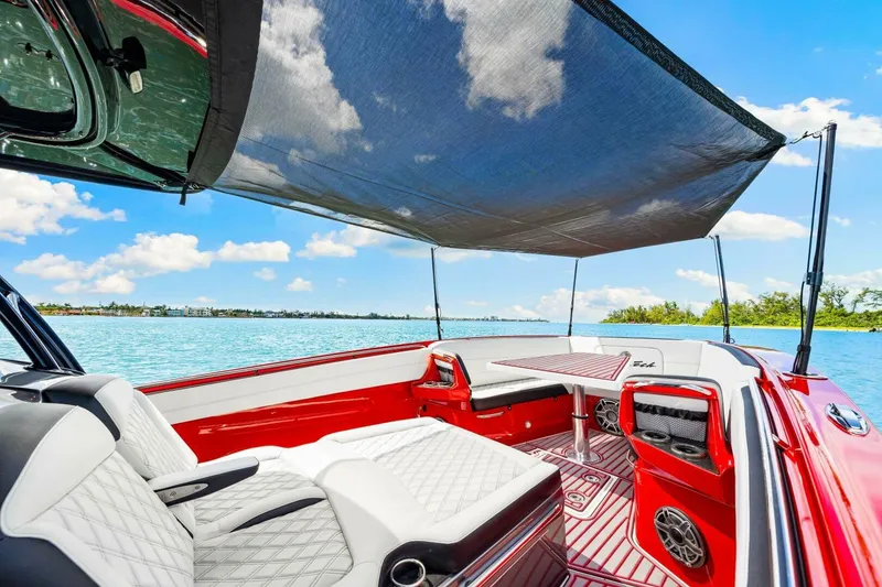 Slide: The Image of 2022 Nor-Tech 390 SS boat interior with luxurious seating and sunshade on a sunny day. - 31