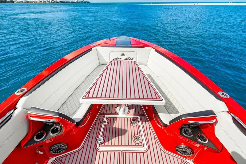 Slide: The Image of 2022 Nor-Tech 390 SS boat interior with red and white seating, table, and ocean view. - 34