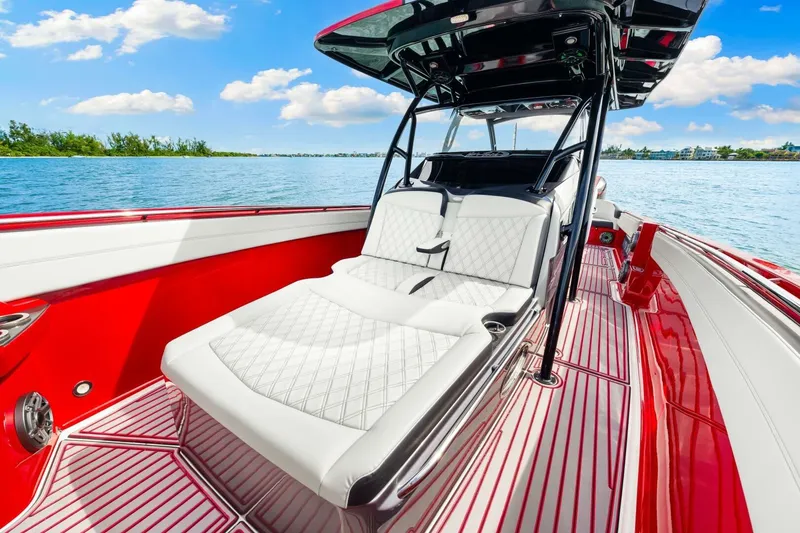 Slide: The Image of 2022 Nor-Tech 390 SS boat with luxurious white seating and vibrant red accents on the water. - 37