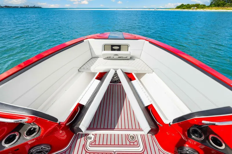 Slide: The Image of 2022 Nor-Tech 390 SS boat interior with red and white seating, on a clear blue water background. - 4