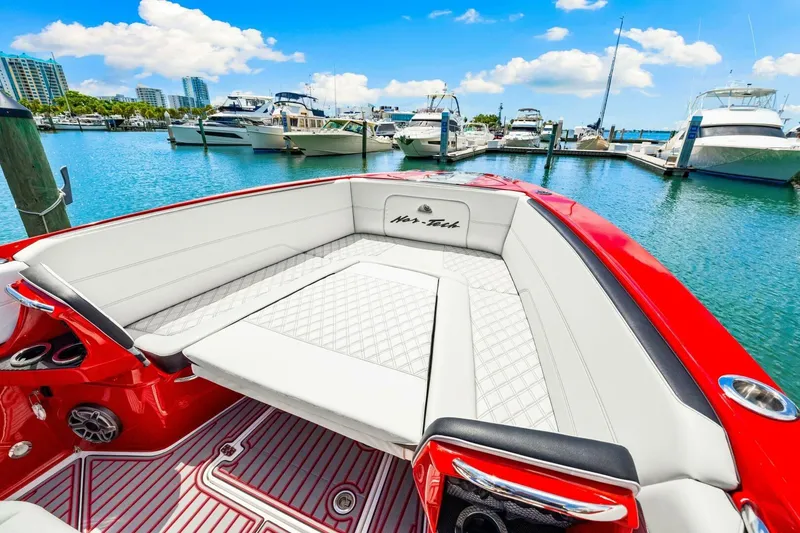Slide: The Image of 2022 Nor-Tech 390 SS boat with luxurious seating in a marina setting. - 42