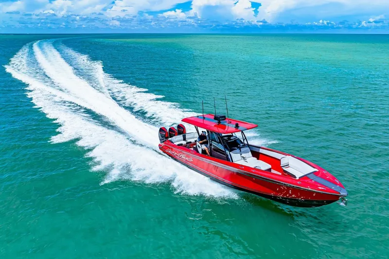 Slide: The Image of Red 2022 Nor-Tech 390 SS speedboat cruising on turquoise ocean waters. - 49