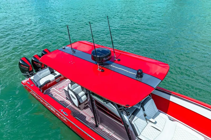 Slide: The Image of 2022 Nor-Tech 390 SS boat with red canopy on turquoise water. - 55