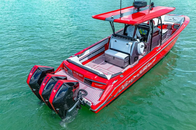 Slide: The Image of Red 2022 Nor-Tech 390 SS boat with triple outboard engines on water. - 58