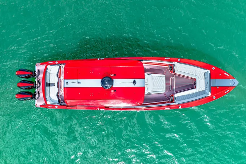 Slide: The Image of Aerial view of 2022 Nor-Tech 390 SS boat in vibrant red on turquoise water. - 6