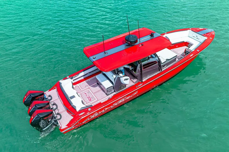 Slide: The Image of Red 2022 Nor-Tech 390 SS boat on clear turquoise water, aerial view. - 61
