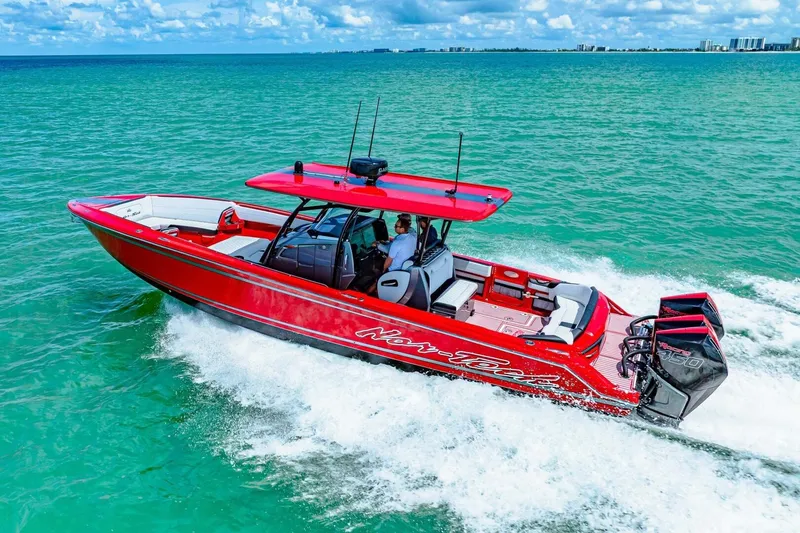 Slide: The Image of Red 2022 Nor-Tech 390 SS boat cruising on turquoise ocean waters. - 67