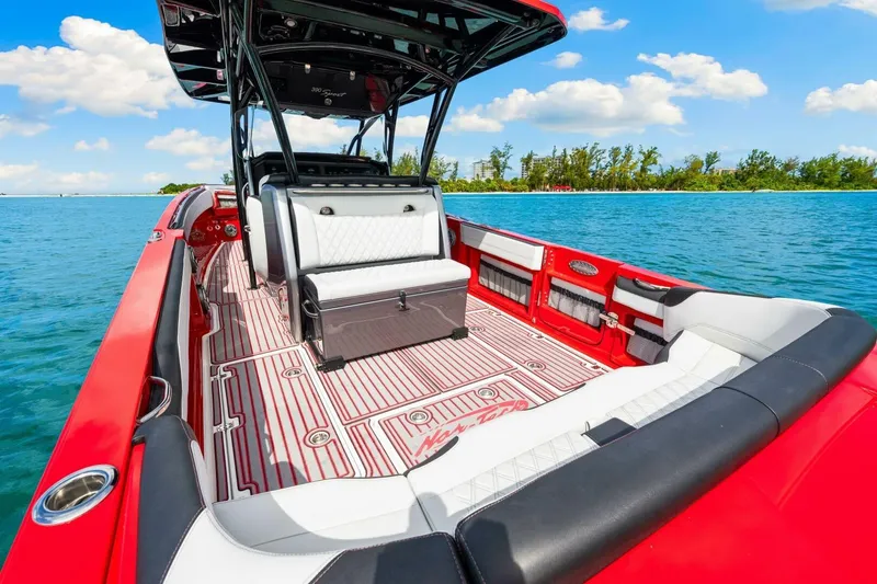 Slide: The Image of 2022 Nor-Tech 390 SS boat with red and white interior on clear blue water. - 7
