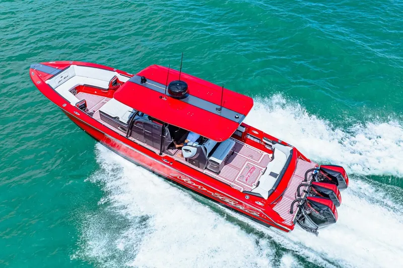 Slide: The Image of Red 2022 Nor-Tech 390 SS boat cruising on turquoise water, showcasing sleek design and powerful engines. - 70