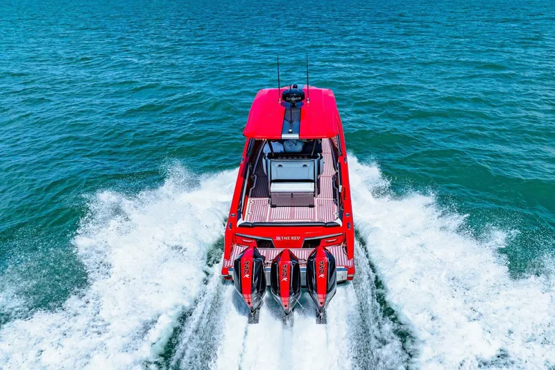Slide: The Image of Red 2022 Nor-Tech 390 SS boat cruising on open water, rear view. - 72