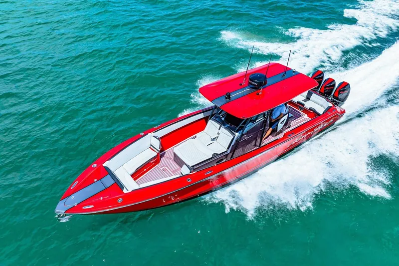 Slide: The Image of 2022 Nor-Tech 390 SS boat cruising on clear blue water, showcasing sleek red design. - 77