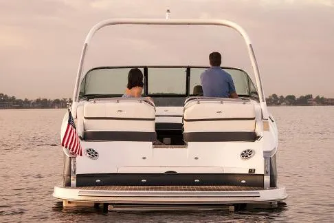 Slide: The Image of Manufacturer Provided Image: 2018 Regal 2800 Bowrider on calm water, rear view with two people seated. - 13
