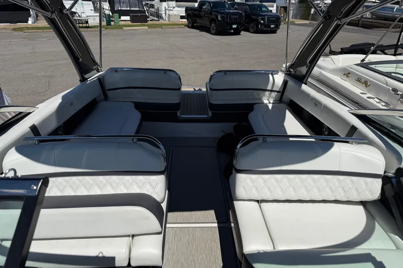 Slide: The Image of 2018 Regal 2800 Bowrider interior with white seating, parked on a marina lot. - 2