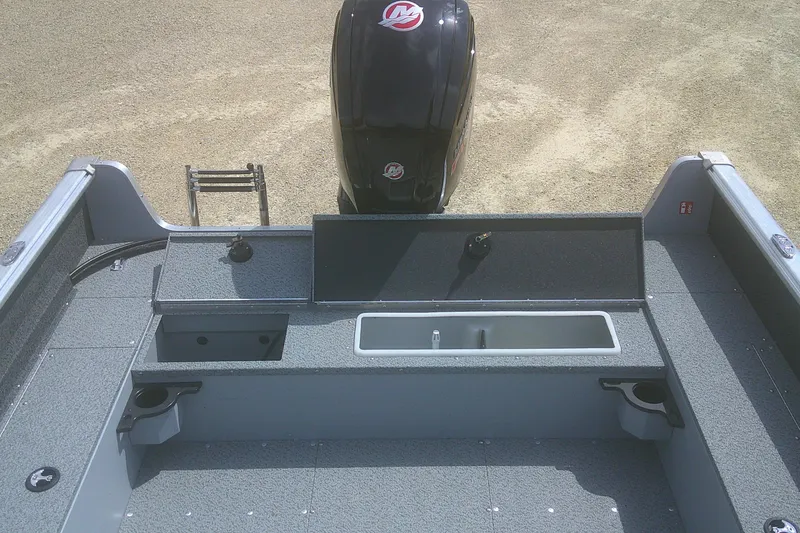 Slide: The Image of 2026 Lund 1800 Explorer SS boat interior with storage compartments and motor. - 13