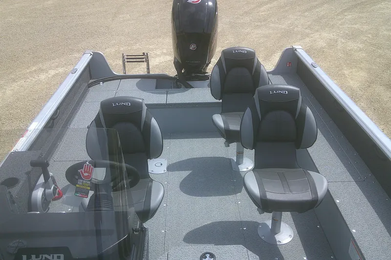 Slide: The Image of 2026 Lund 1800 Explorer SS boat interior with three black seats and steering console. - 7