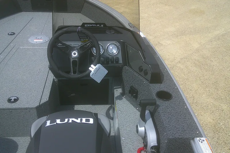 Slide: The Image of 2026 Lund 1800 Explorer SS boat interior with steering wheel and dashboard controls. - 8