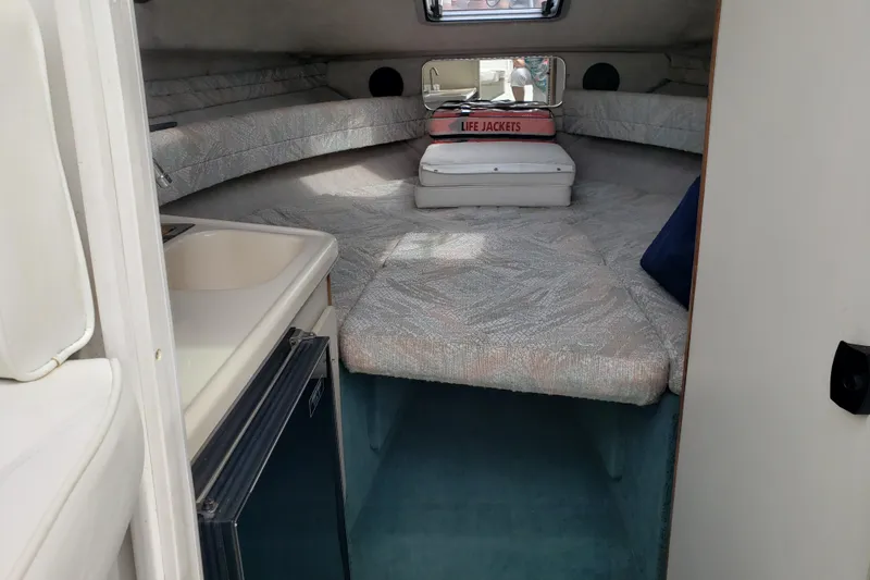 Slide: The Image of 1993 Searay 250EC boat cabin interior with bed, sink, and life jackets. - 12