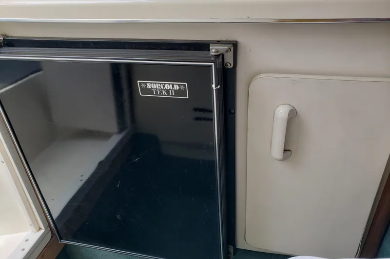 Slide: The Image of 1993 Searay 250EC boat interior with Norcold Tek II refrigerator and storage compartment. - 14