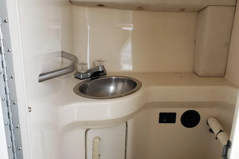 Slide: The Image of 1993 Searay 250EC boat interior sink with faucet and storage. - 15