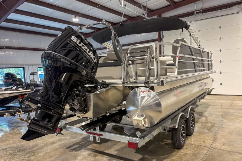 Slide: The Image of 2025 Trifecta 22UL LE pontoon boat with Suzuki outboard motor in a showroom. - 8