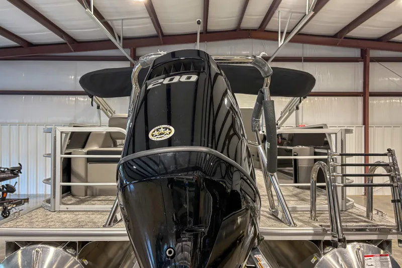 Slide: The Image of 2025 Trifecta 22UL LE pontoon boat with powerful 200 HP engine in a storage facility. - 9