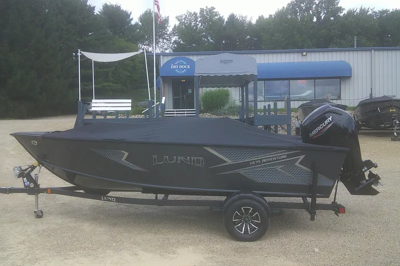 Slide: The Image of 2026 Lund 1675 Adventure SS boat on trailer, covered, with Mercury outboard motor. - 15