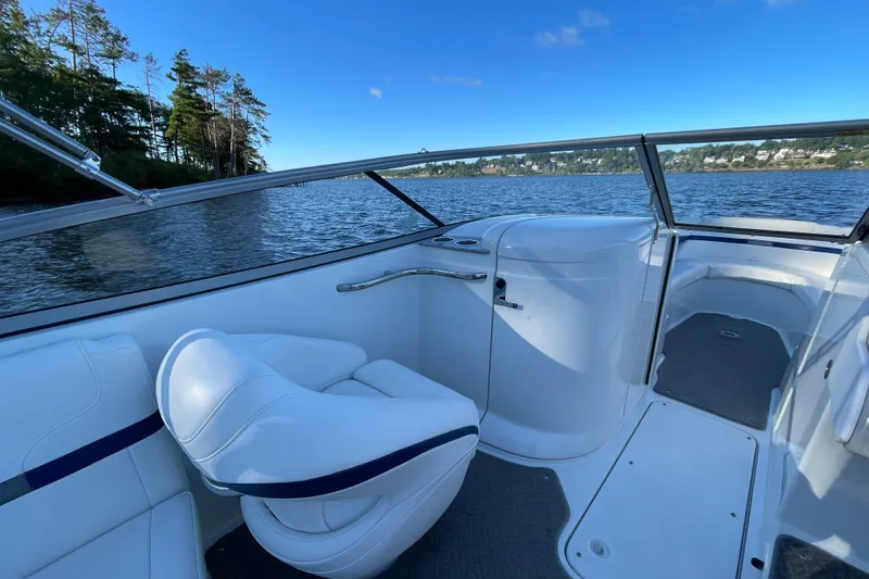 Slide: The Image of 2005 Formula 240 Bowrider interior with white seating, on a scenic lake. - 10