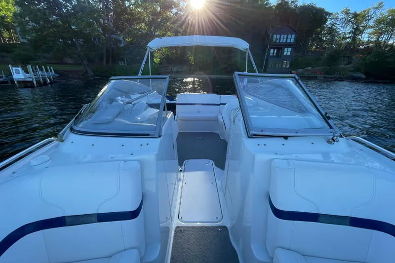 Slide: The Image of 2005 Formula 240 Bowrider boat on a serene lake with sunlit trees. - 14