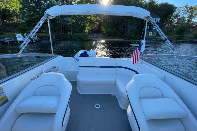 Slide: The Image of 2005 Formula 240 Bowrider boat interior with white seating, lake view, and American flag. - 15