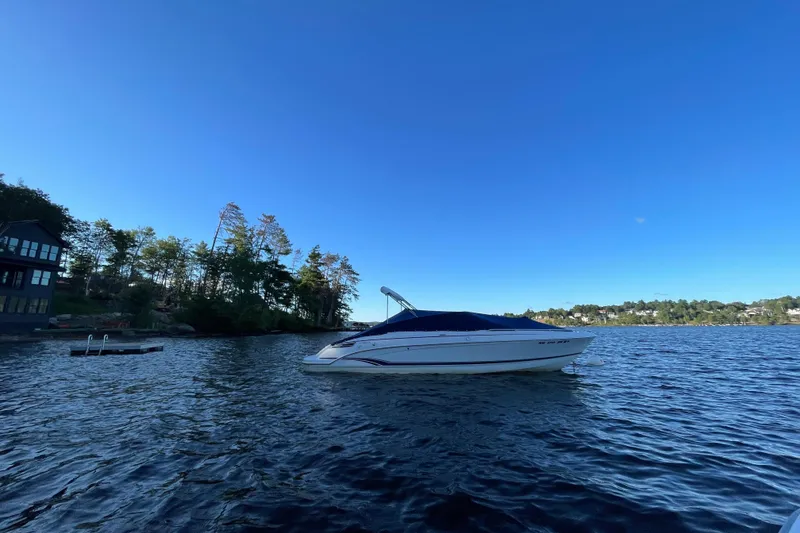 Slide: The Image of 2005 Formula 240 Bowrider boat on a serene lake with clear blue sky. - 19