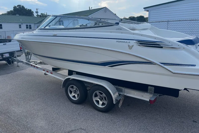 Slide: The Image of 2005 Formula 240 Bowrider boat on trailer, parked outdoors. - 23