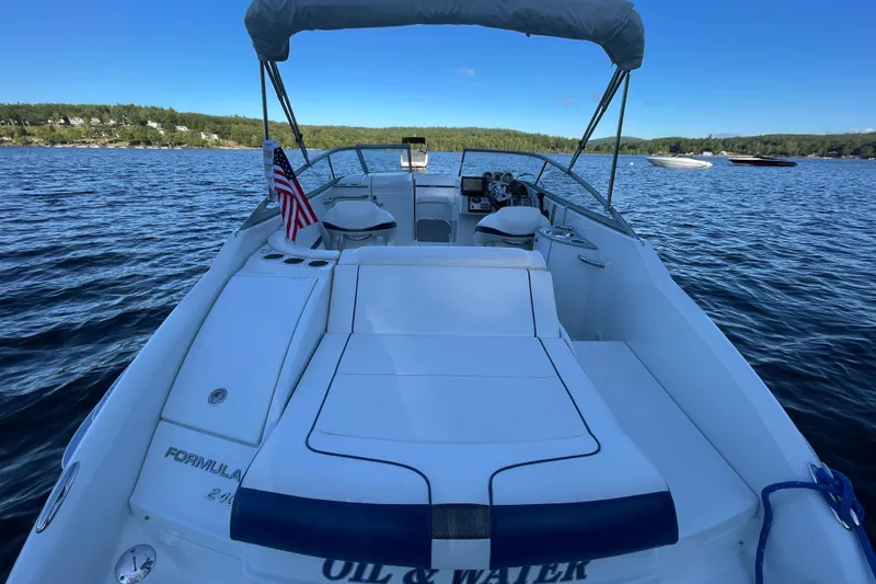 Slide: The Image of 2005 Formula 240 Bowrider boat on a lake, featuring spacious seating and American flag. - 3