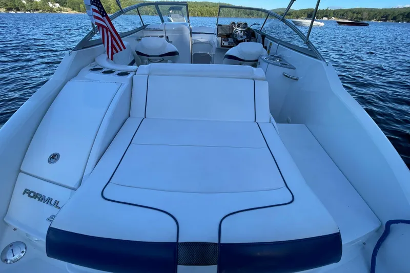 Slide: The Image of 2005 Formula 240 Bowrider boat with spacious seating on a serene lake. - 4