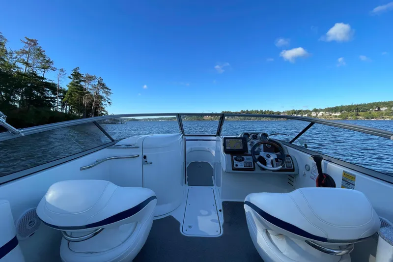 Slide: The Image of 2005 Formula 240 Bowrider boat interior with steering wheel, seats, and scenic water view. - 5