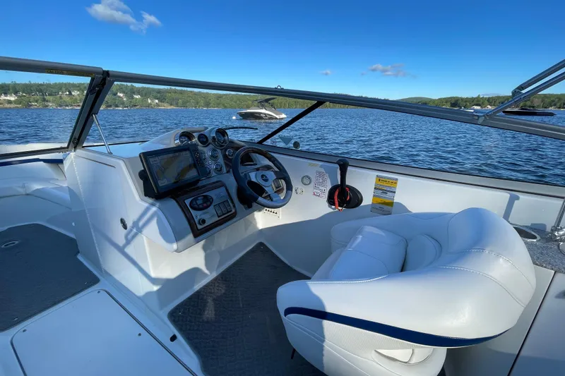 Slide: The Image of 2005 Formula 240 Bowrider boat interior with steering wheel and control panel on a sunny lake. - 7