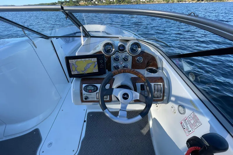 Slide: The Image of 2005 Formula 240 Bowrider dashboard with GPS, steering wheel, and gauges on a lake. - 8