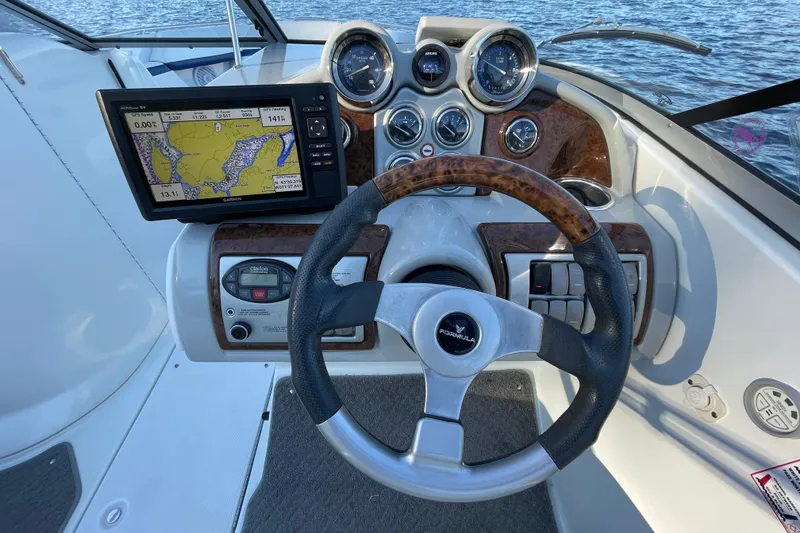 Slide: The Image of 2005 Formula 240 Bowrider dashboard with GPS, gauges, and steering wheel on water. - 9