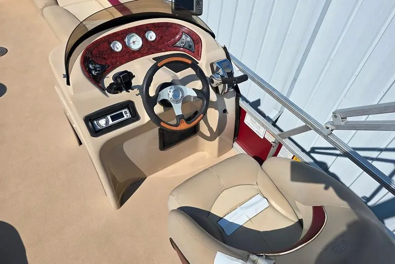Slide: The Image of 2012 Sun Tracker 22 Party Barge Deluxe helm with steering wheel and gauges. - 3
